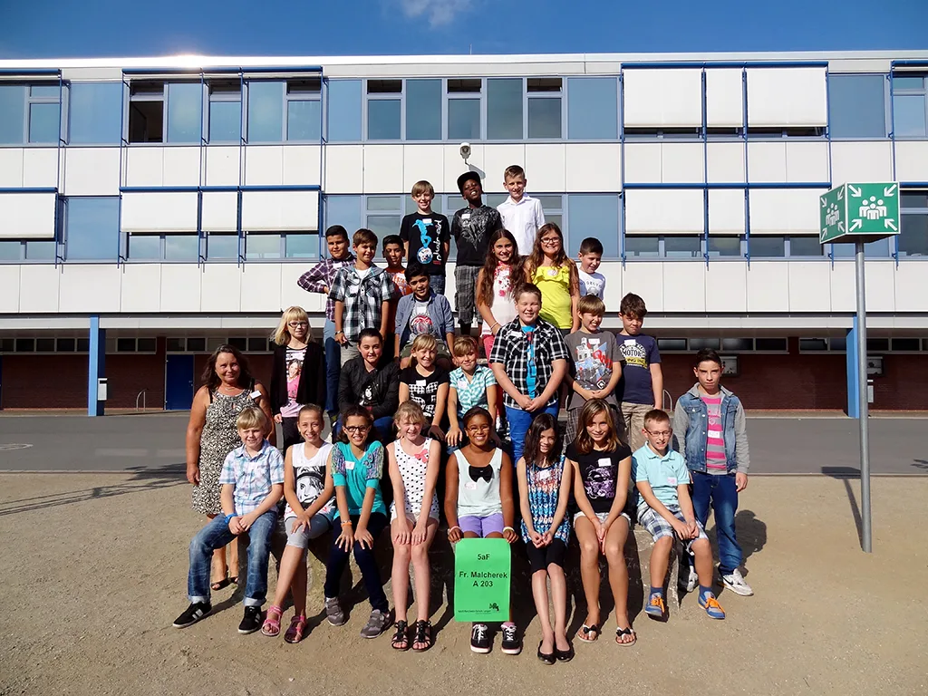 Klassenfoto einer neuen fünften Klasse vor dem Gebäude.